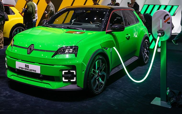 Renault 5 E-Tech verte branchée à une borne de recharge